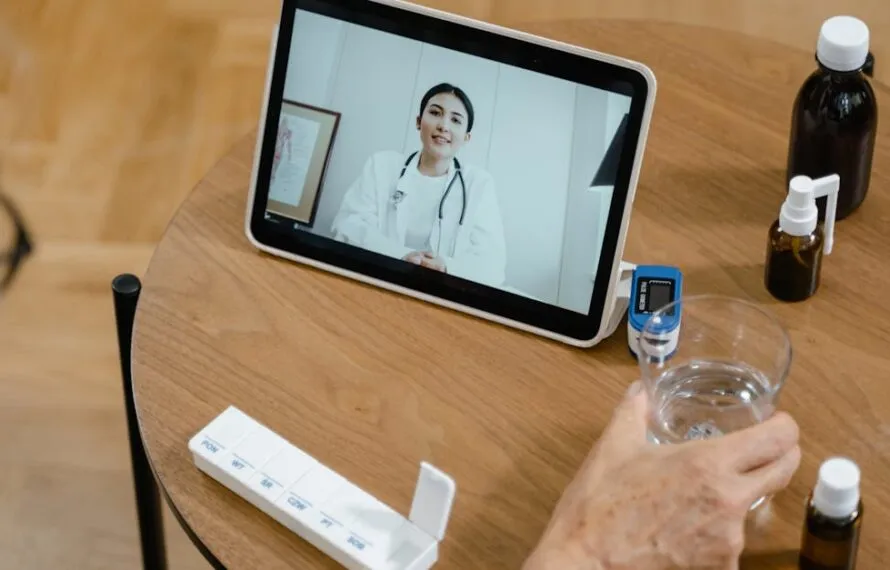Pessoa assistindo a uma consulta médica por videochamada em tablet.
